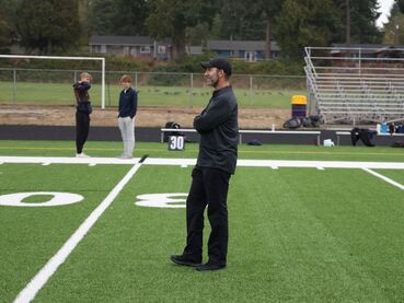 Kevin Alschuler, PhD, standing on a football field
