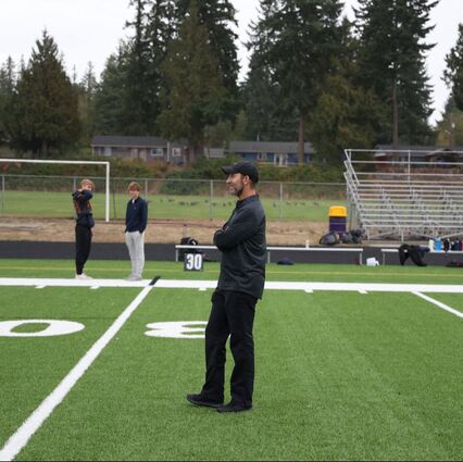 Kevin Alschuler, PhD, standing on a football field